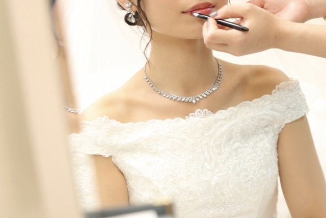ウェディングドレスをきてヘアメイクをうける新婦