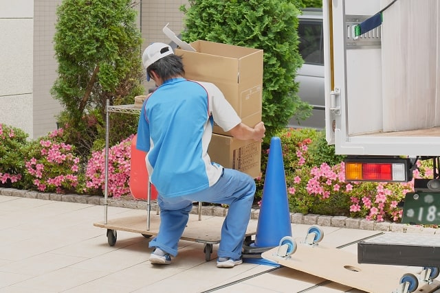 荷物を運ぶ引っ越し業者の社員さん