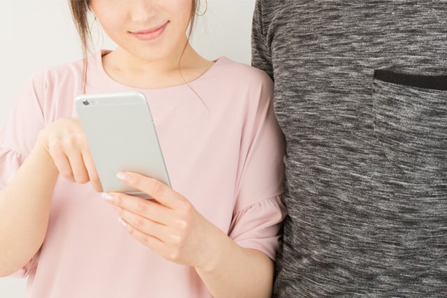 スマホで電話をしようとするカップル
