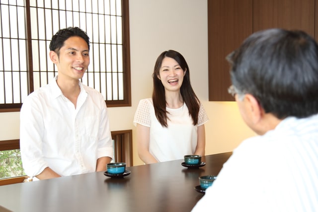 彼女の両親と談笑するカップル