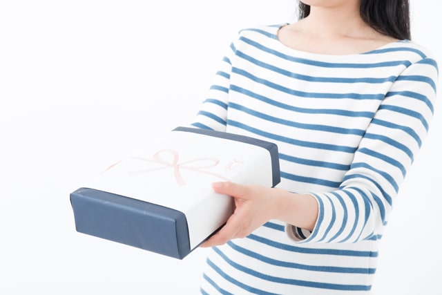 のし付きの手土産を手渡す女性