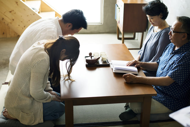 結婚挨拶で頭を下げるカップル