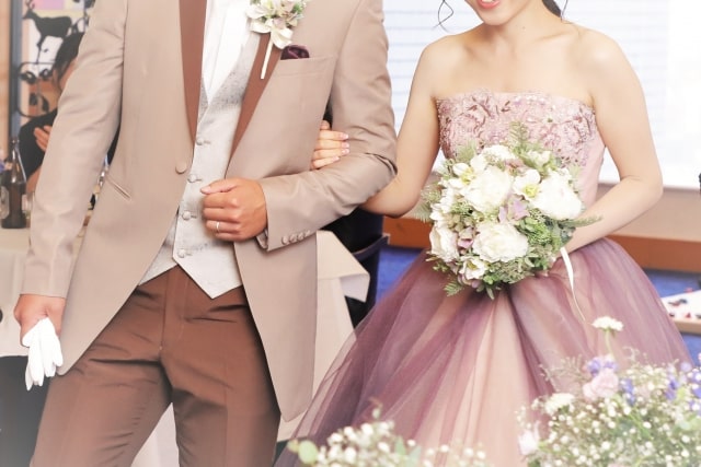 披露宴で腕を組む新郎新婦さま