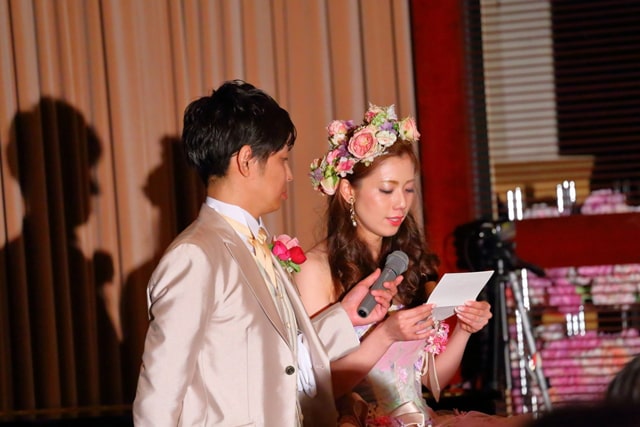 花嫁の手紙でマイクを持つ新郎と手紙を読む新婦