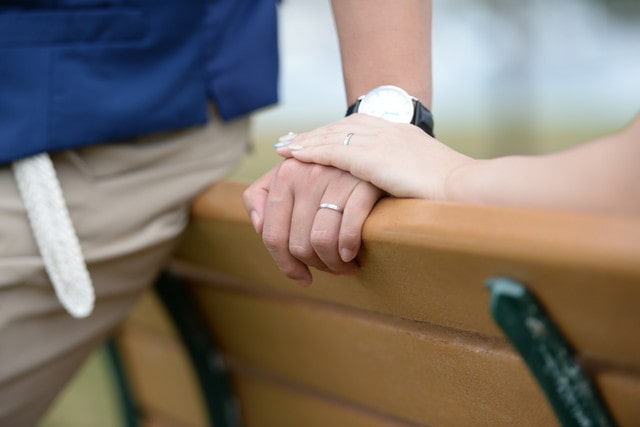 結婚指輪をはめた手を合わせるカップル