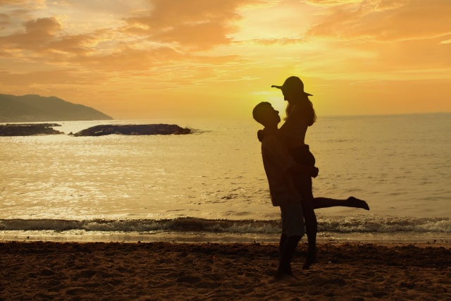 海辺で抱き合うカップル
